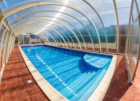 Covered summer pool. The covered area of the outdoor pool for hotel. Water retains heat longer and protect from the wind